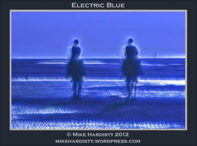 Two horse riders on the beach with a blue corona effect round them
