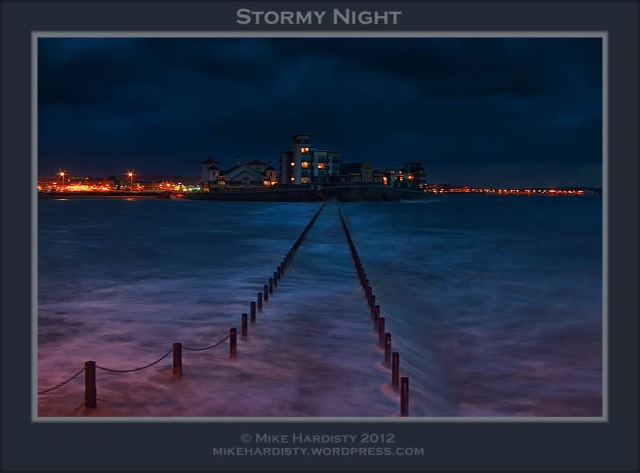 Stormy night at Knightstone Island with the waves breaking over the causeway